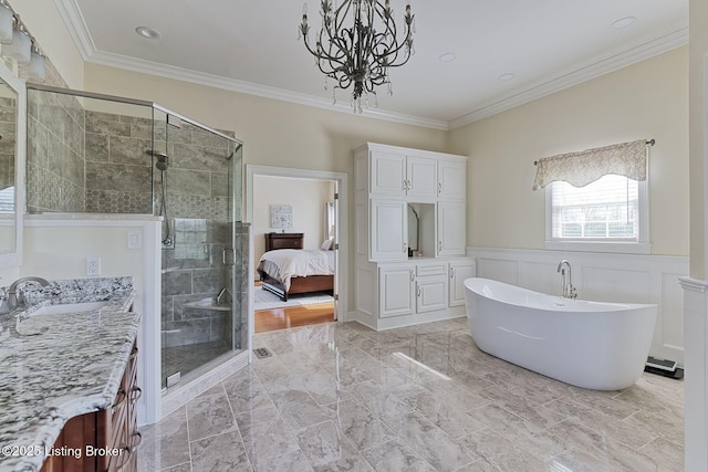 ensuite bathroom featuring an inviting chandelier, vanity, crown molding, and a stall shower
