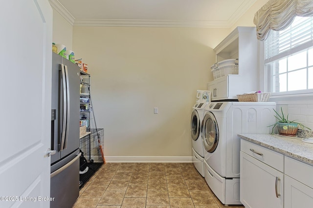 clothes washing area with separate washer and dryer, cabinet space, crown molding, and baseboards