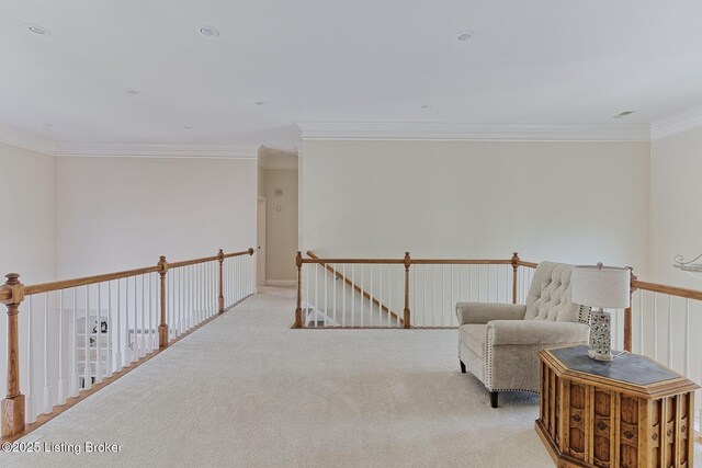 sitting room featuring crown molding, carpet, and an upstairs landing