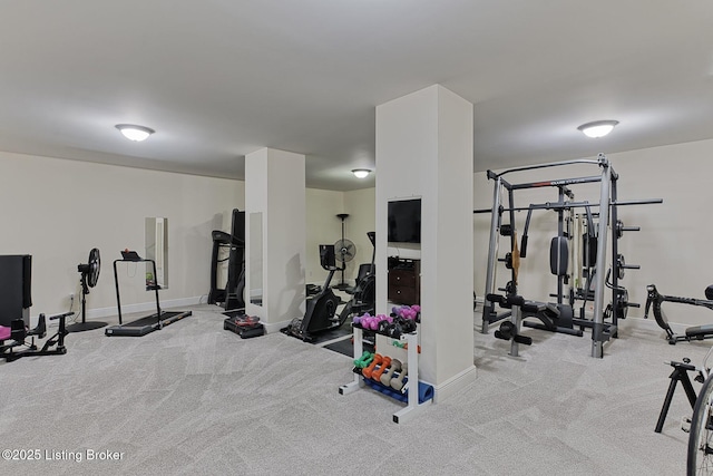 exercise room with baseboards and carpet flooring