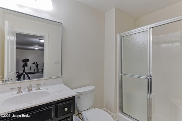 bathroom with toilet, a shower stall, and vanity