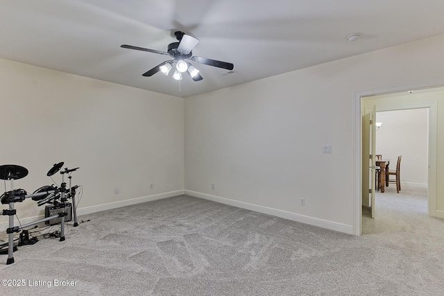 empty room with baseboards, ceiling fan, carpet, and visible vents