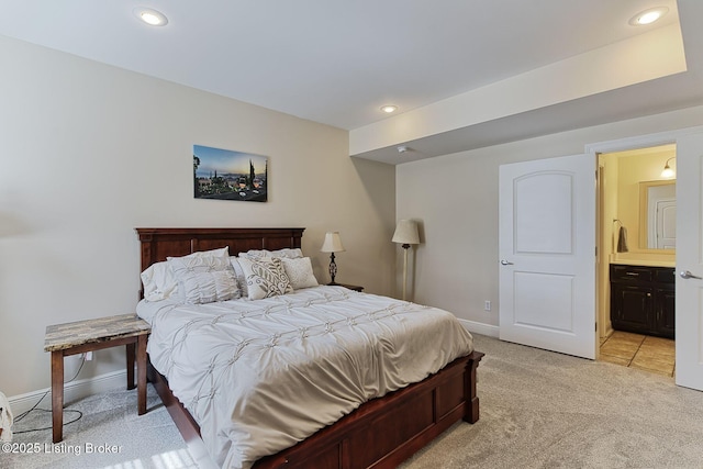 bedroom featuring baseboards, recessed lighting, ensuite bathroom, and light carpet
