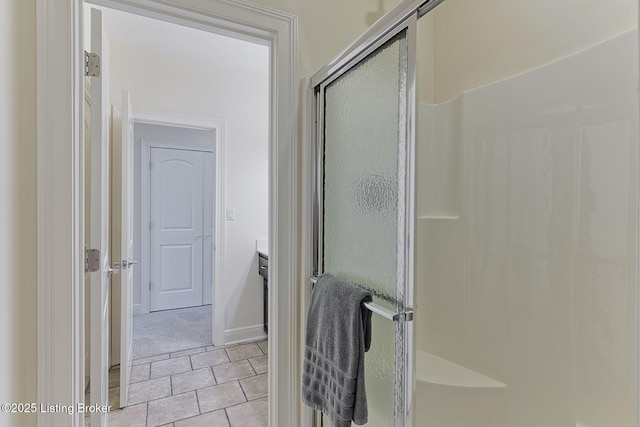 bathroom featuring vanity, baseboards, and a stall shower