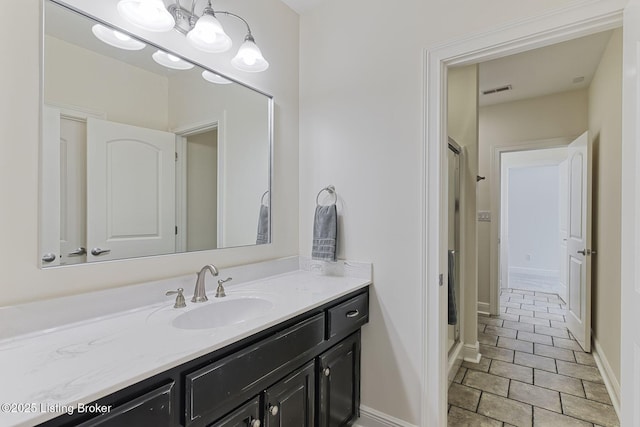 bathroom with vanity, baseboards, tile patterned floors, and visible vents