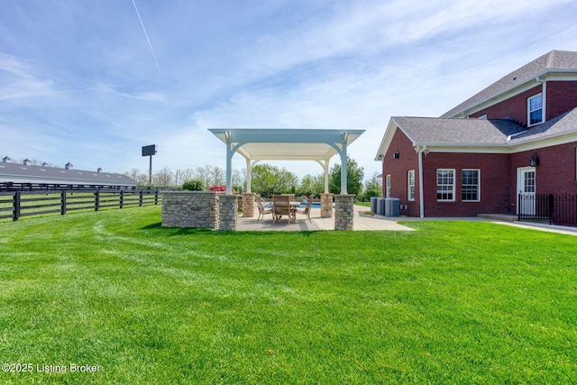 view of yard with a patio, fence, and central AC unit