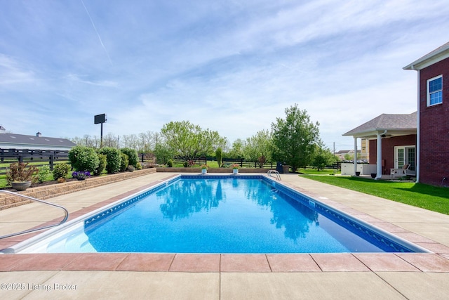 outdoor pool with a patio and fence
