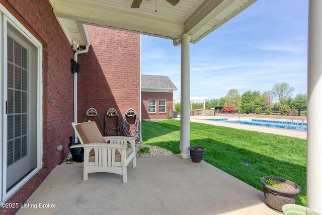 view of patio with ceiling fan and a fenced in pool