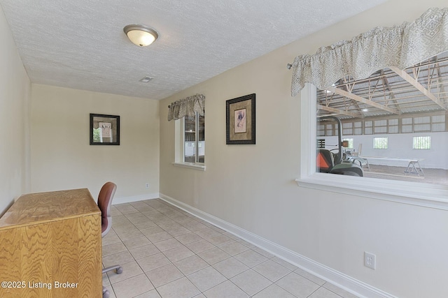 dining space featuring a textured ceiling, tile patterned floors, and baseboards