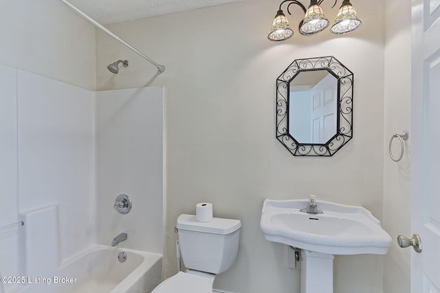 bathroom featuring a sink, bathtub / shower combination, and toilet