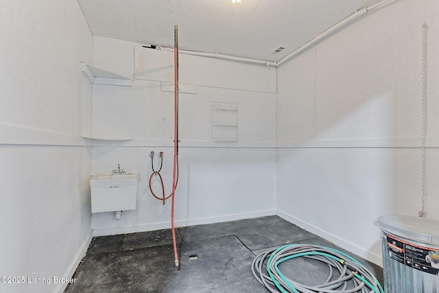 laundry room featuring a sink and baseboards