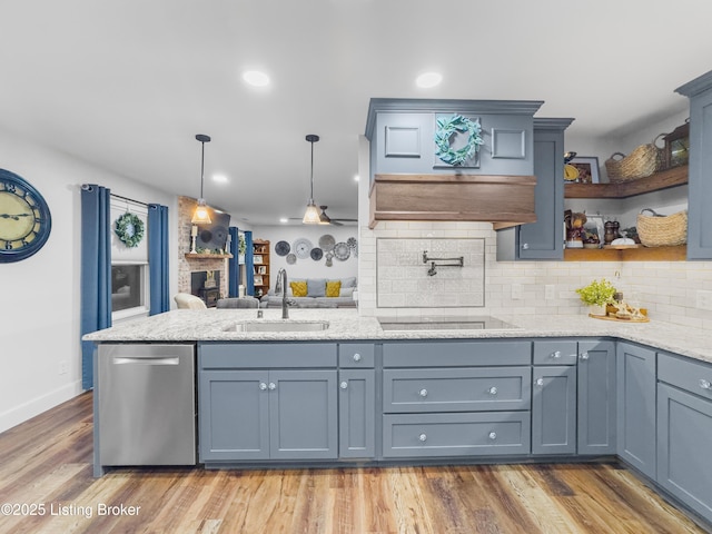 kitchen featuring tasteful backsplash, stainless steel dishwasher, black electric cooktop, a sink, and a peninsula
