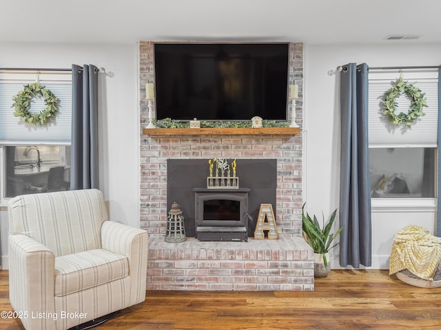 living area with visible vents and wood finished floors