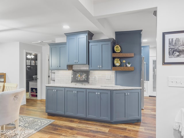 kitchen with open shelves, dark wood-style flooring, recessed lighting, backsplash, and blue cabinetry