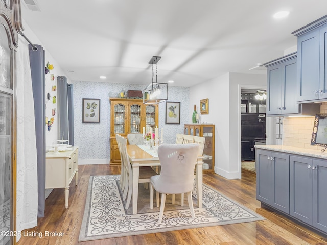 dining space featuring wallpapered walls, dark wood finished floors, baseboards, and visible vents
