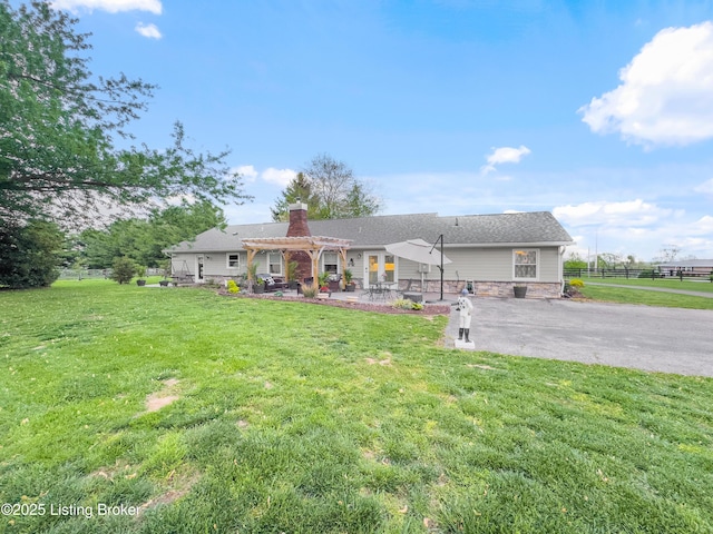 ranch-style home featuring fence, a pergola, a front yard, a chimney, and a patio
