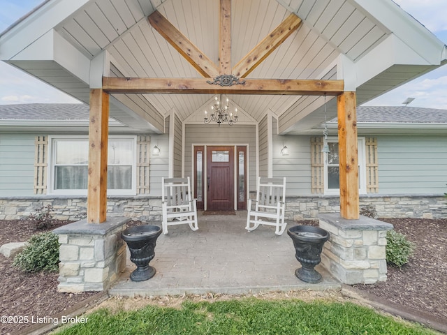 doorway to property with covered porch and stone siding