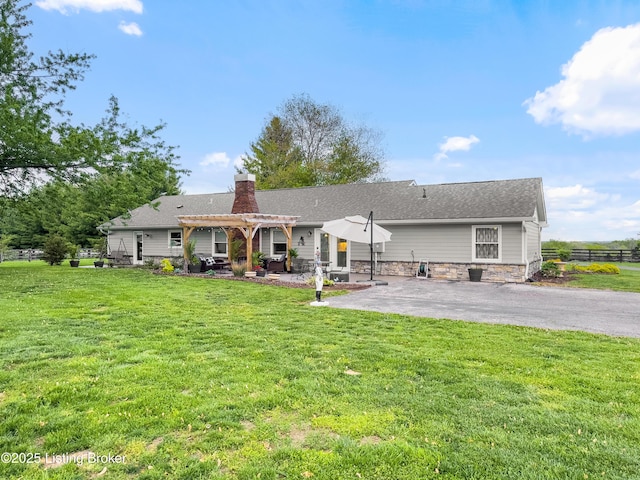 back of property with a patio area, a yard, a pergola, and a chimney