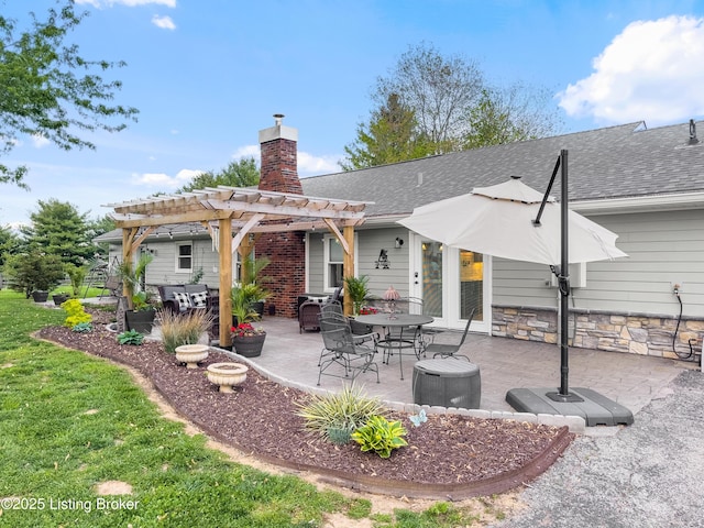 rear view of house featuring roof with shingles, a pergola, a chimney, and a patio