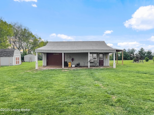 back of property with an outdoor structure, a yard, and a storage unit