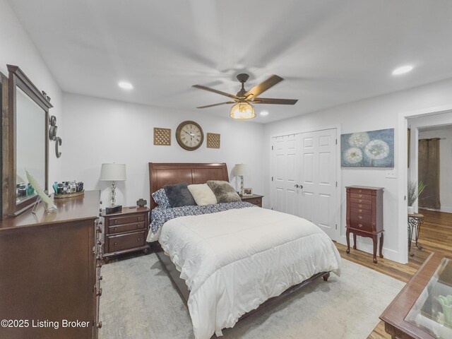 bedroom with recessed lighting, a ceiling fan, wood finished floors, and a closet