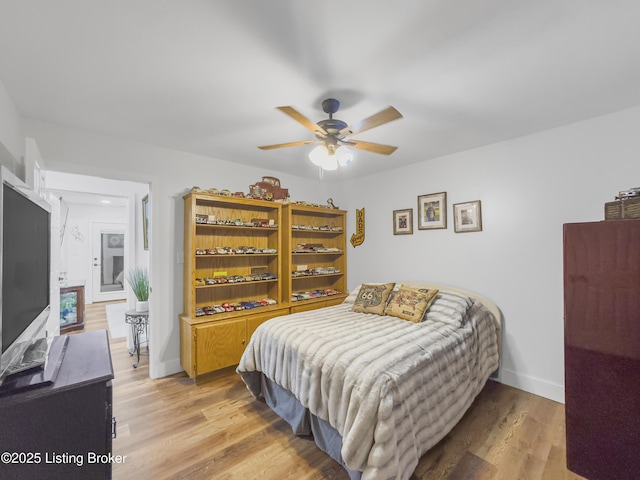 bedroom with baseboards, ceiling fan, and light wood-style floors