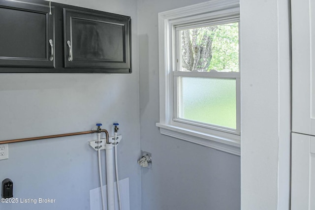 washroom with washer hookup, cabinet space, and a wealth of natural light
