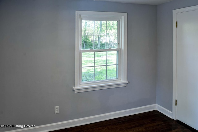 empty room featuring baseboards, plenty of natural light, and dark wood finished floors
