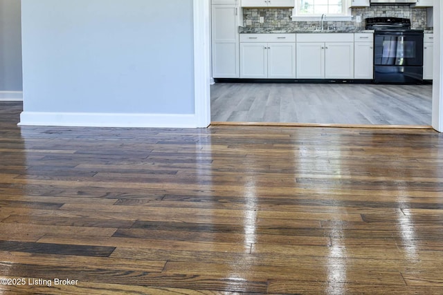 interior space featuring a sink, baseboards, and dark wood-style floors