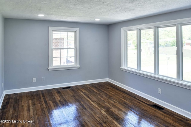 spare room with baseboards, a textured ceiling, and a healthy amount of sunlight