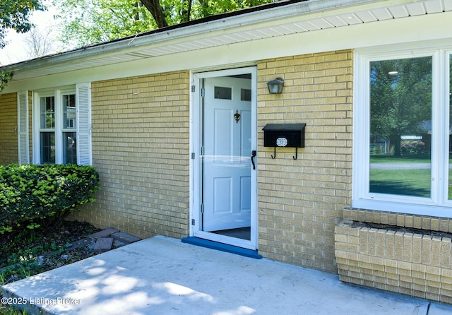 doorway to property with brick siding