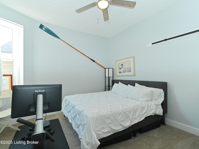 carpeted bedroom featuring baseboards and a ceiling fan