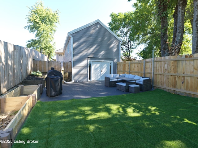exterior space with a lawn, an outdoor living space, a patio area, and a fenced backyard