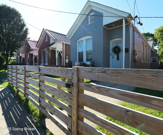 view of side of property with brick siding and fence