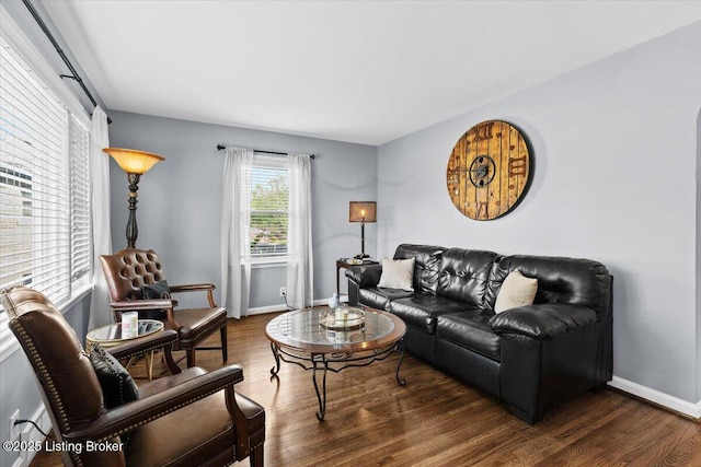 living area with baseboards and wood finished floors