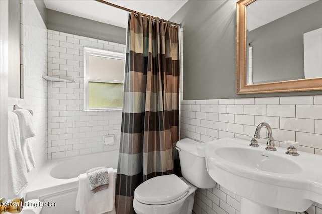 full bath featuring a sink, tile walls, toilet, and shower / tub combo