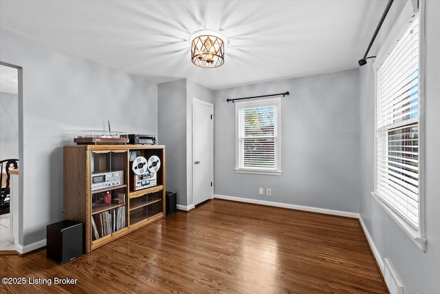 interior space with baseboards, wood finished floors, and a chandelier