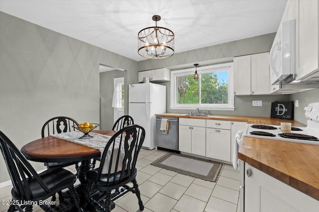 kitchen featuring a sink, a chandelier, wood counters, white appliances, and white cabinetry