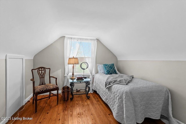 bedroom featuring vaulted ceiling and hardwood / wood-style flooring