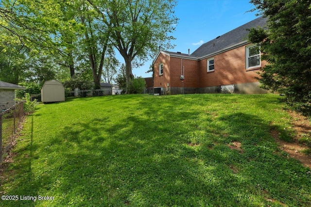 view of yard featuring central AC unit, fence, an outbuilding, and a shed