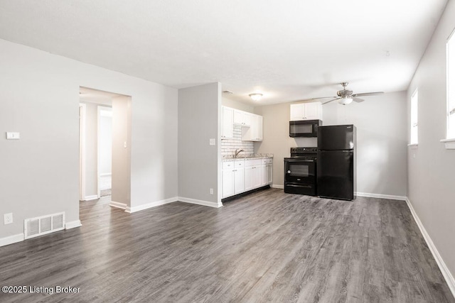 unfurnished living room with visible vents, a ceiling fan, baseboards, and dark wood-type flooring