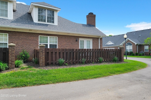 10002 Brownsboro Gardens Cir, Louisville, KY 40241 - view of property exterior featuring fence, a shingled roof, and brick siding