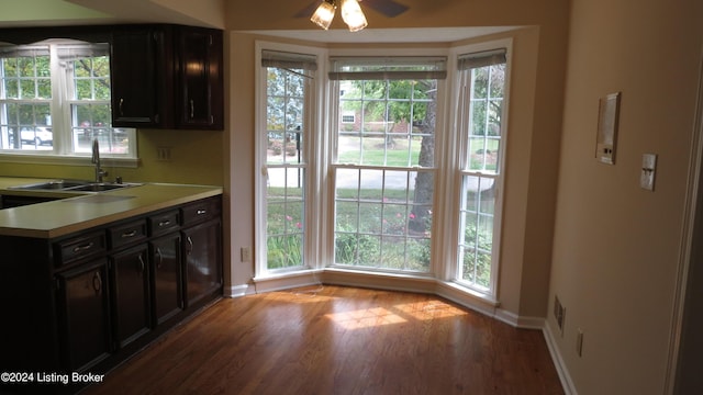 kitchen featuring baseboards, light countertops, wood finished floors, and a healthy amount of sunlight