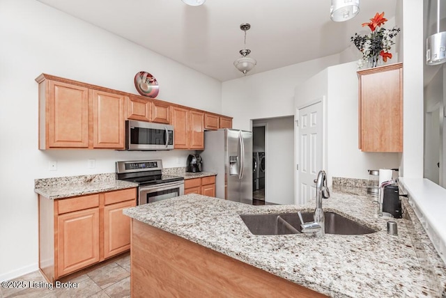 220 Rockcrest Way, Louisville, KY 40245 - kitchen featuring appliances with stainless steel finishes, separate washer and dryer, a sink, light stone counters, and a peninsula
