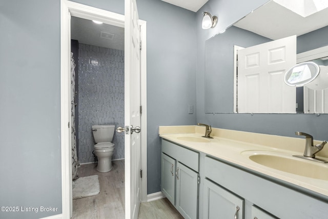 3003 Coffee Tree Ct, Crestwood, KY 40014 - bathroom with wood finished floors, toilet, baseboards, double vanity, and a skylight