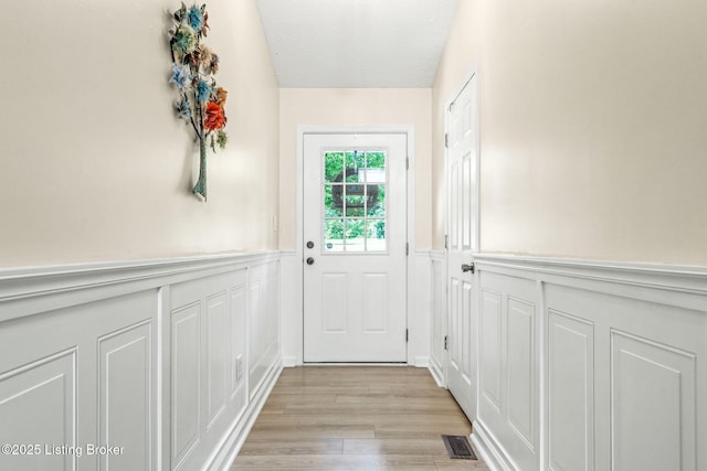 3003 Coffee Tree Ct, Crestwood, KY 40014 - doorway to outside featuring a decorative wall, wainscoting, light wood finished floors, and a textured ceiling