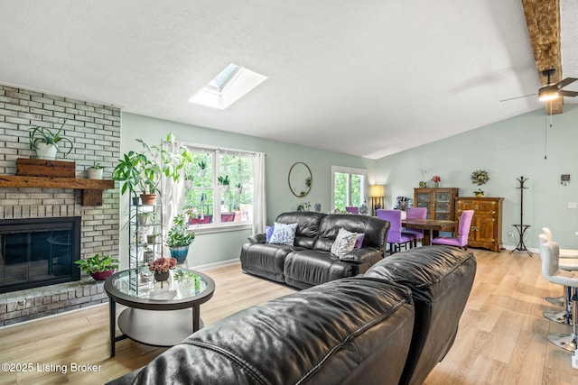 3003 Coffee Tree Ct, Crestwood, KY 40014 - living area featuring vaulted ceiling, wood finished floors, a skylight, a brick fireplace, and a ceiling fan
