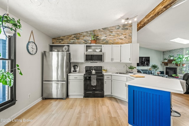 3003 Coffee Tree Ct, Crestwood, KY 40014 - kitchen featuring stainless steel appliances, a sink, a peninsula, light wood-style flooring, and a textured ceiling