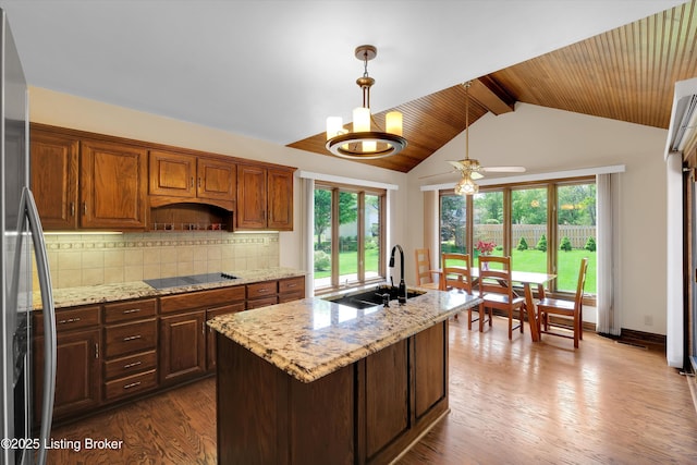 418 Glensford Dr, Louisville, KY 40245 - kitchen featuring a sink, black electric cooktop, stainless steel fridge, tasteful backsplash, and dark wood-type flooring