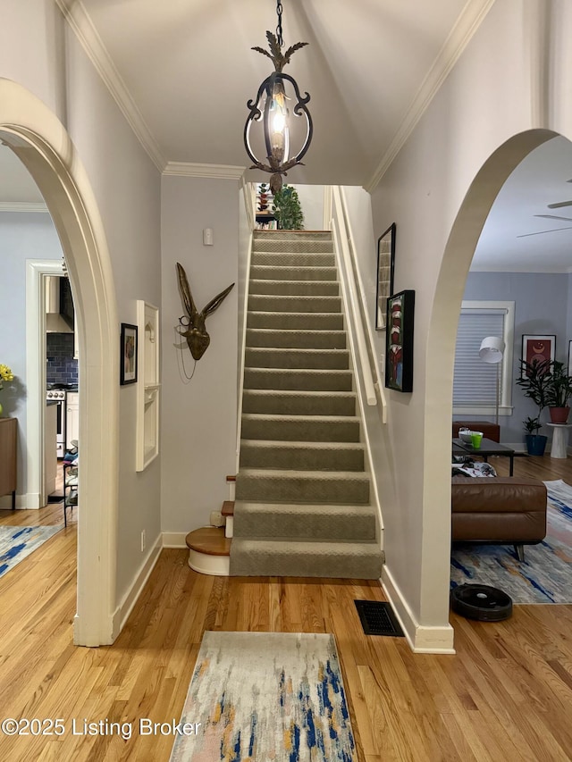 2302 Woodford Pl, Louisville, KY 40205 - stairs with crown molding, baseboards, wood finished floors, and visible vents